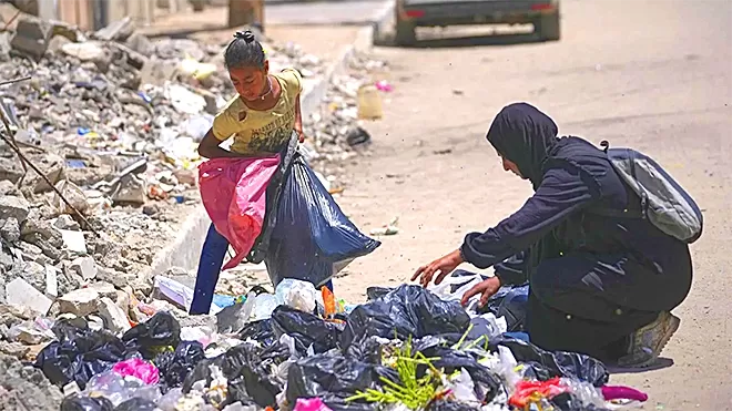 آهالي متعففين يبحثون عن الطعام في براميل القمامة